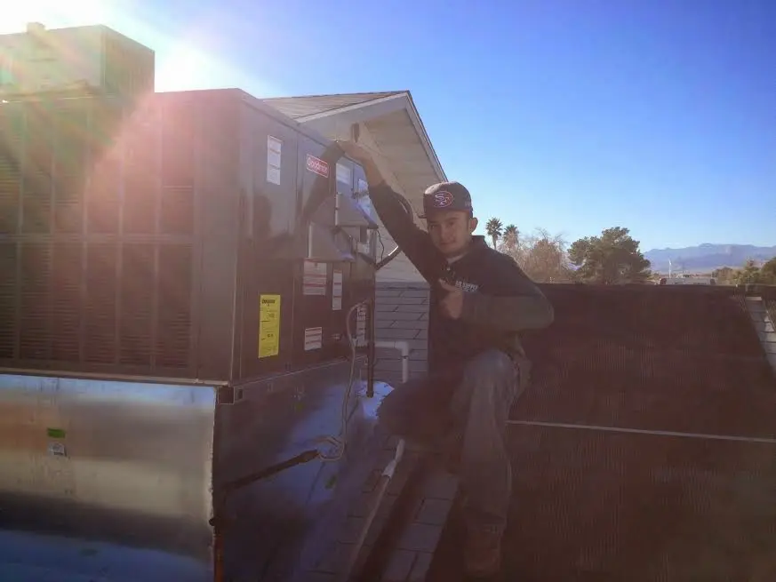 HVAC technician performing Air Duct Cleaning on a rooftop unit in Antwerp
